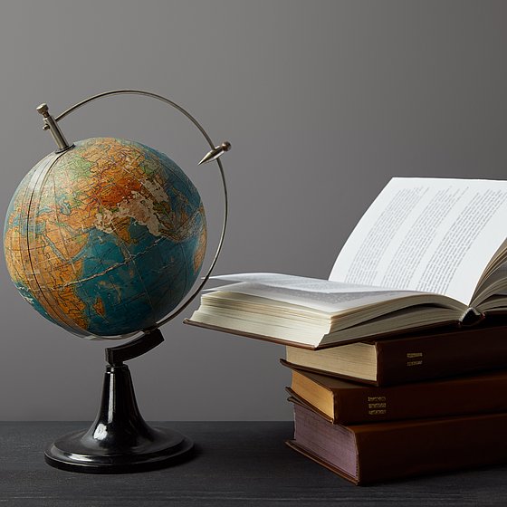 Ein Globus neben einem Stapel Bücher